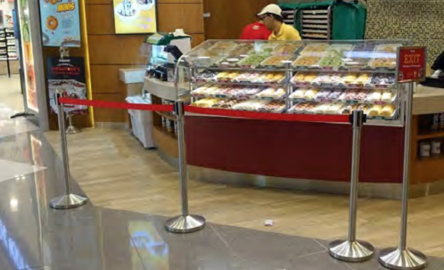 Retractable barrier in a baker's shop for crowd management